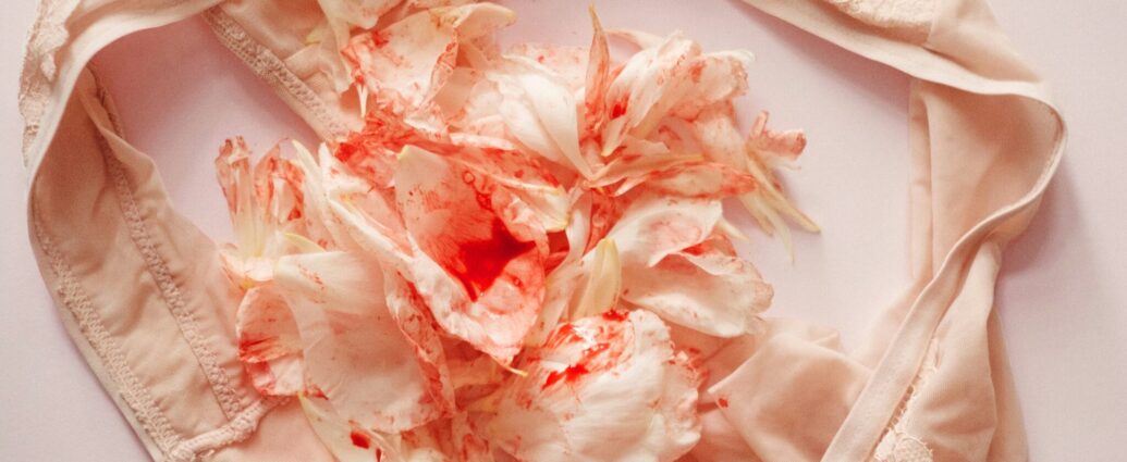 A pair of underwear with mottled red flowers in the middle that gives the illusion of menstrual bleeding.