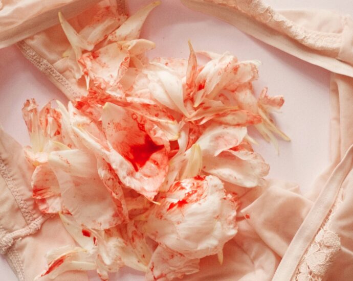 A pair of underwear with mottled red flowers in the middle that gives the illusion of menstrual bleeding.