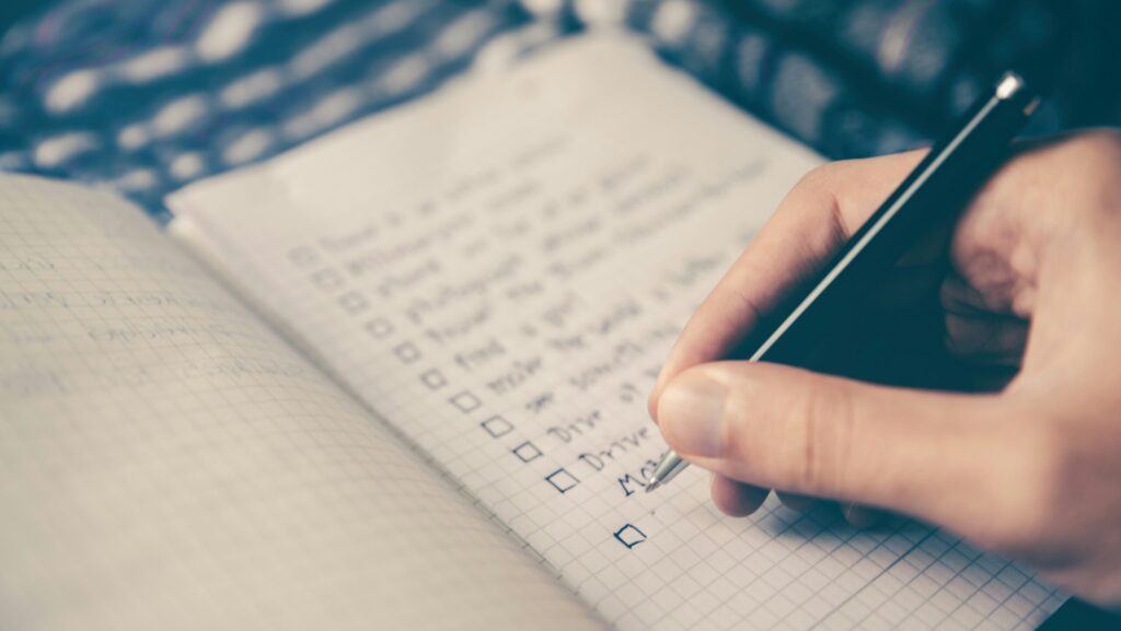 A long list of New Year's Resolutions being written in a notebook