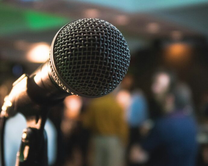 Microphone on stage with people blurred in the background.