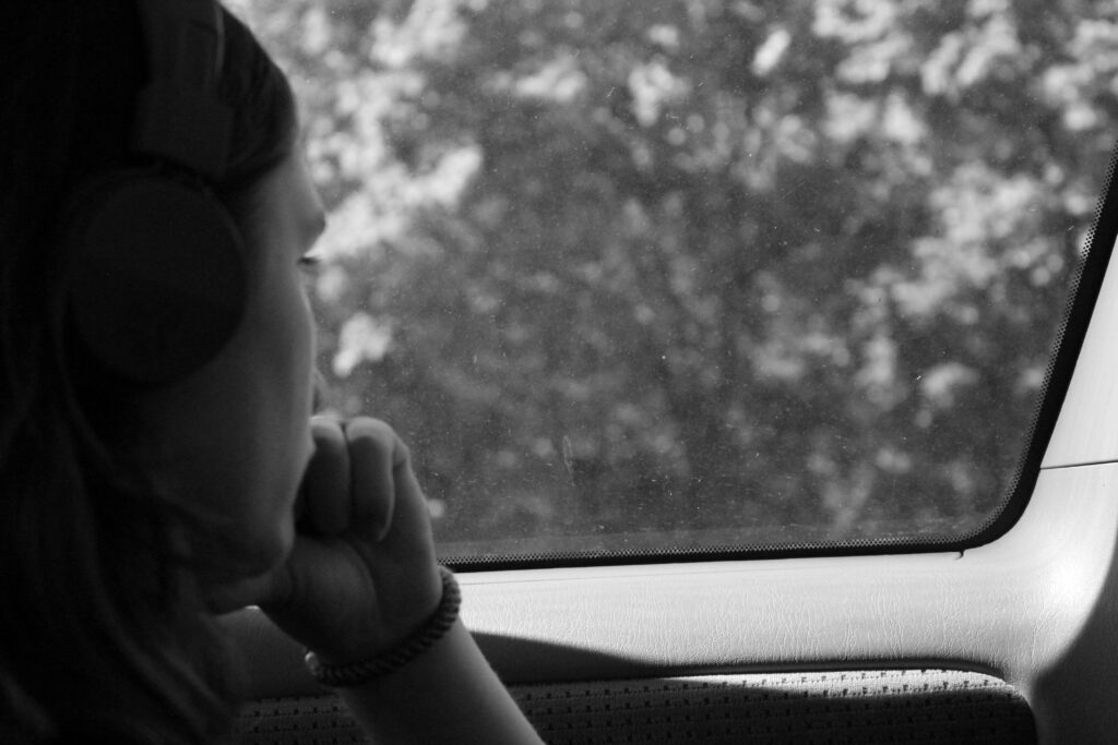 Woman with SAD looking out a car window at trees