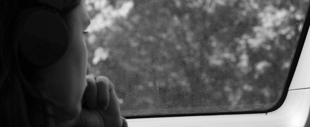 Woman with SAD looking out a car window at trees