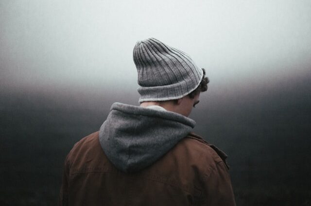 A man wearing a beanie with his back to the camera