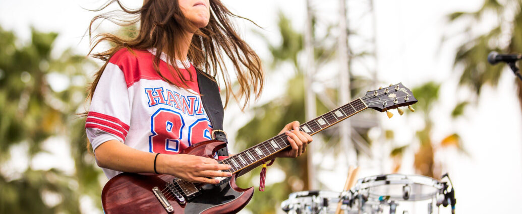Danielle Haim playing guitar at Coachella Festival.