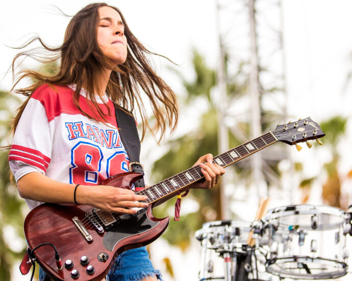 Danielle Haim playing guitar at Coachella Festival.