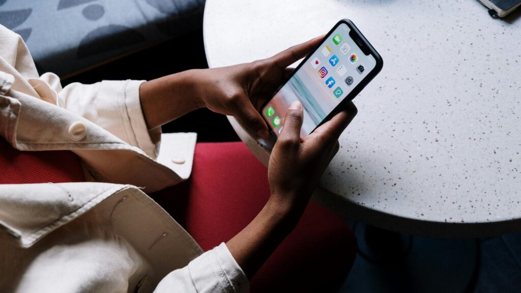 Person holding phone looking at social media apps