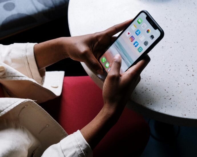Person holding phone looking at social media apps